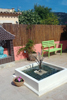 Copper Bulrush Fountain in a white square pond